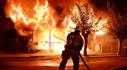 A Kern County firefighter puts water on a house fire near Taft, CA, in November 2017.