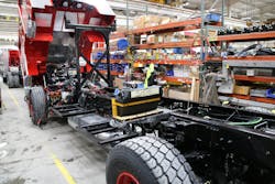 An aerial with a big block engine has the Aftertreatment components installation in progress. In this instance, the DEF tank is located in the fender panel area ahead of the rear wheel. An aerial with a big block engine has the Aftertreatment components installation in progress. In this instance, the DEF tank is located in the fender panel area ahead of the rear wheel.