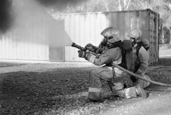 Firefighters applying gas cooling during training. The cone angle is approximately 60 degrees and is inclined 45 degrees with the ground.