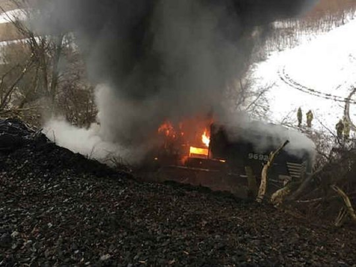 Firefighters look on as a Norfolk Southern freight engine burns after derailing in Attica, NY, on Thursday, Feb. 15, 2018.