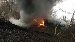 Firefighters look on as a Norfolk Southern freight engine burns after derailing in Attica, NY, on Thursday, Feb. 15, 2018.