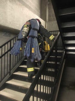 Brandon Anderson taking the stairs in full PPE and with a bundle of hose on his back during training. Brandon Anderson taking the stairs in full PPE and with a bundle of hose on his back during training.