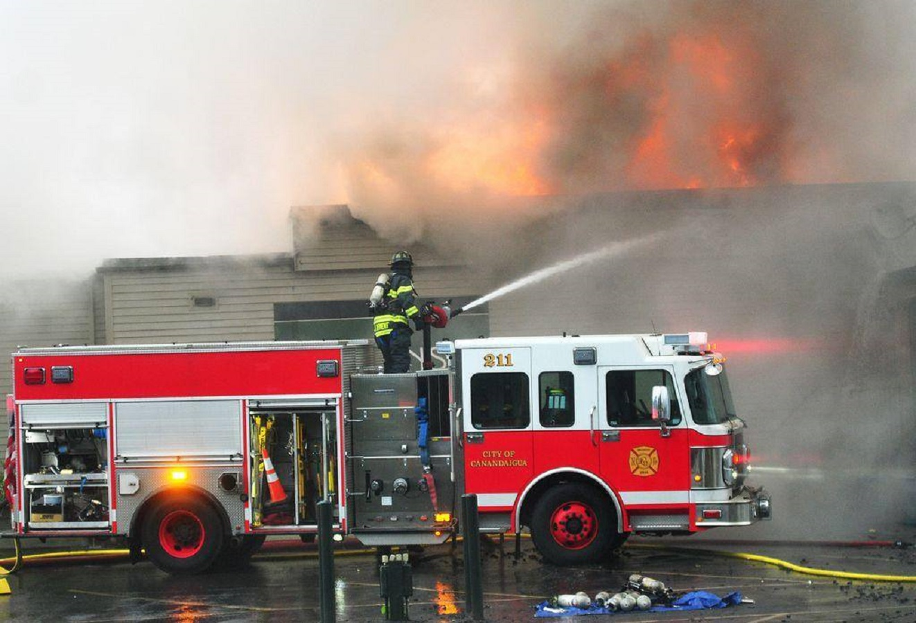 A Canandaigua, NY, firefighter pours water on a fire on Dec. 8, 2017.