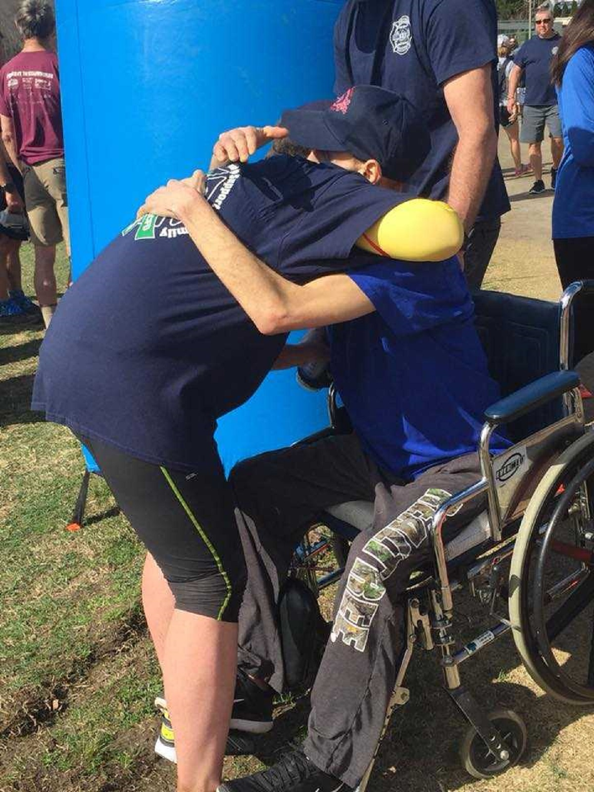 Asheville, NC, Division Chief Joy Ponder hugs terminally ill firefighter Will Willis after completing the Black Mountain Marathon in his honor on Saturday, Feb. 24, 2018.