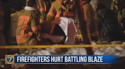 A Watertown, NY, firefighter is removed from the scene by stretcher after being injured in a wall collapse during a fire at a vacant building on Monday, Feb. 19, 2018.