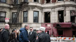 New York City Mayor Bill de Blasio, in blue windbreaker, and FDNY Commissioner Daniel Nigro, wearing tinted glasses, at the scene of a fire in Harlem on March 22, 2018, that killed FDNY Lt. Michael Davidson.