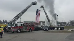 York, PA, area firefighters salute their fallen colleagues Ivan Flanscha and Zachary Anthony as smoke rises in the background after a house fire broke out during a memorial procession on Wednesday, March 28, 2018.