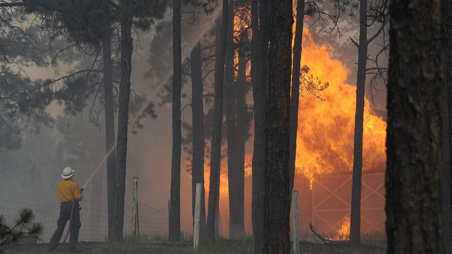 A firefighter fights a blaze in a detached garage in the Black Forest, CO, area on June 12, 2013.