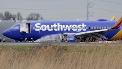 Firefighters spray a Southwest Airlines plane with a damaged engine at Philadelphia International Airport on April 17, 2018.