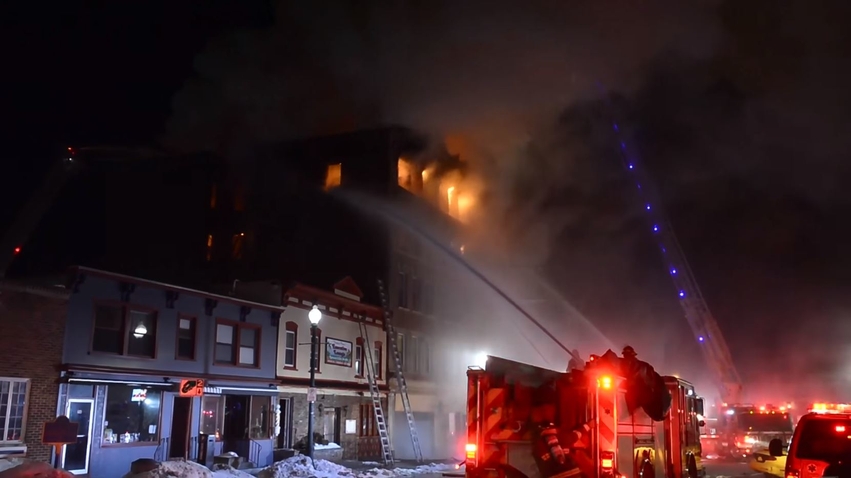 The upper floors of an apartment building burn during a fire that killed four people in Schenectady, NY, on March 6, 2015.