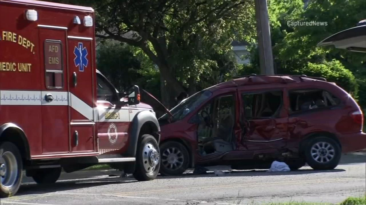 A badly damaged minivan sits in front of a fire department ambulance after the two vehicles were involved in a wreck in Aurora, IL, on Wednesday, May 16, 2018.