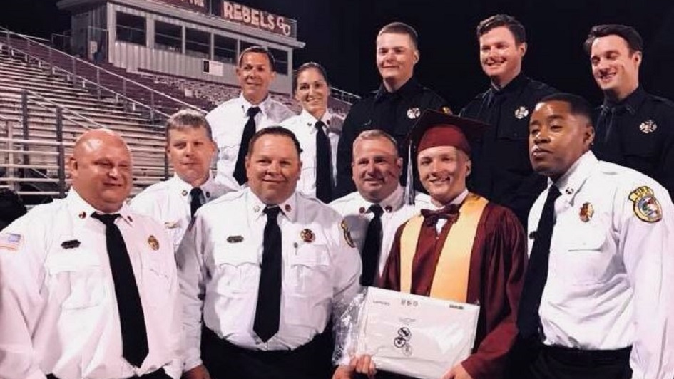 Gautier firefighters pose with George County High School graduate Joey Kauppi on Friday, May 19, 2018, as they stand in for his injured father and their colleague, Lt. Dan Kauppi.