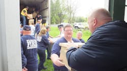 Florida, NY, firefighters help unload a truck full of Christmas gifts sent to fire survivor Safyre Terry in 2015.