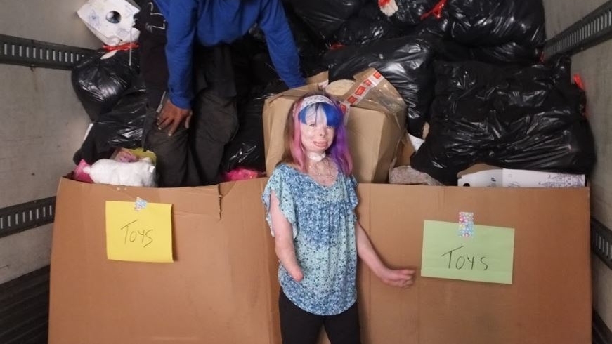 Fire survivor Safyre Terry, 10, stands in a tractor trailer full of gifts she received after a Facebook post asking for Christmas cards went viral in 2015.