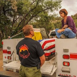 Amanda speaks with Duane Steinbrink, Wildland Division Chief of the Prescott Fire Department, while sitting with Eric&rsquo;s casket before his funeral.