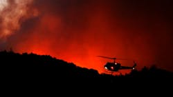 A helicopter prepares to drop water as the Tubbs Fire threatens the Oakmont community along Highway 12 in Santa Rosa, CA, on Oct. 13, 2017. A helicopter prepares to drop water as the Tubbs Fire threatens the Oakmont community along Highway 12 in Santa Rosa, CA, on Oct. 13, 2017.