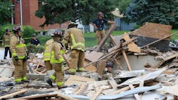 Columbus firefighters removing debris as they probe a suspected natural gas explosion that leveled a duplex on Friday, June 22, 2018.