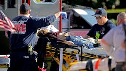 Coral Springs-Parkland Fire Department paramedics tend to a victim outside Marjory Stoneman Douglas High School in Parkland, FL, after a shooting on Feb. 14, 2018.