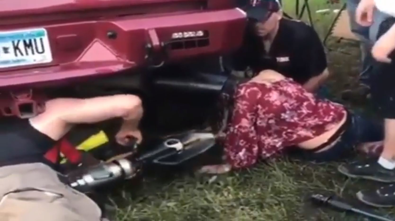 A firefighter prepares to use a power saw to free a woman whose head was stuck in a oversize tailpipe during a music festival last weekend in Winsted, MN.