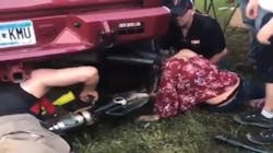 A firefighter prepares to use a power saw to free a woman whose head was stuck in a oversize tailpipe during a music festival last weekend in Winsted, MN.