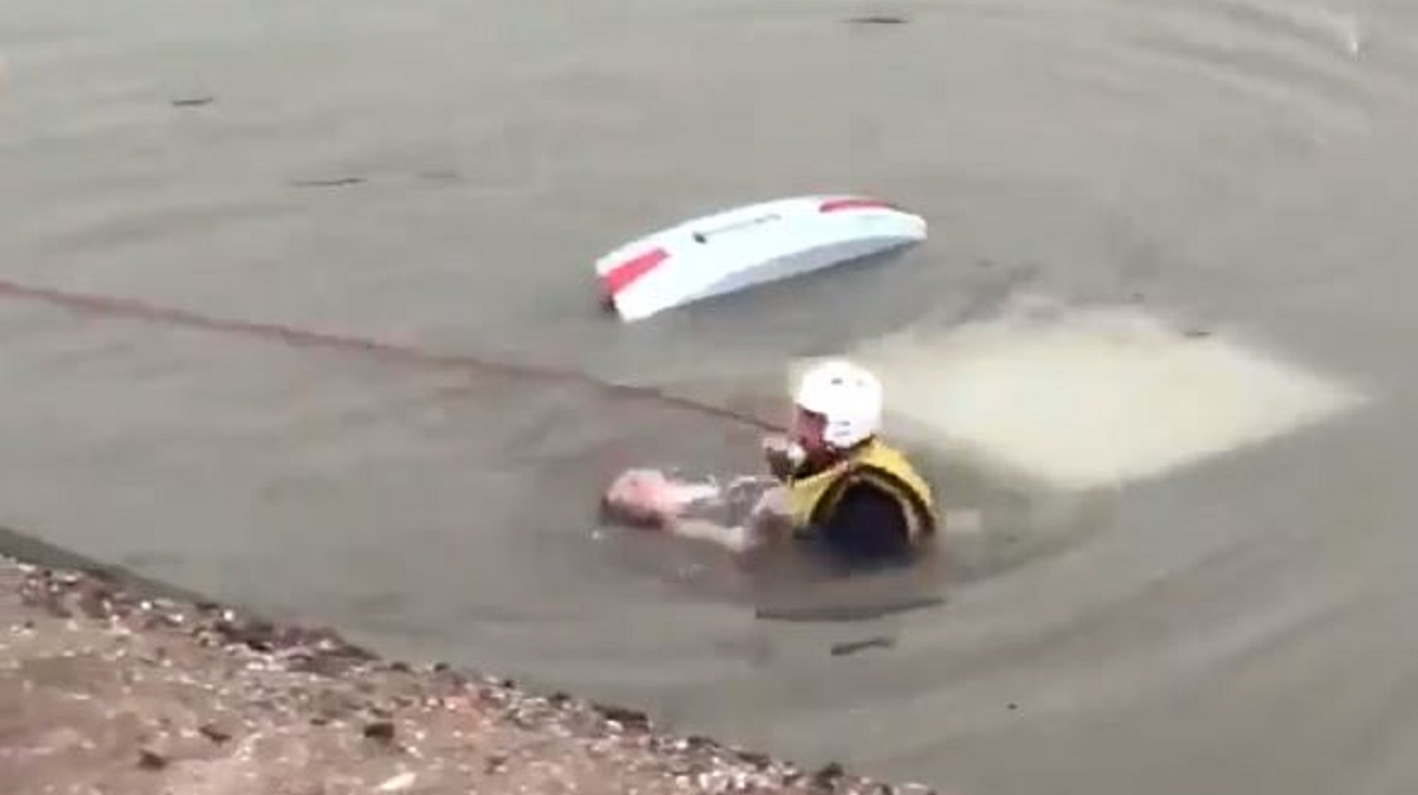 A rescue diver brings a woman to the surface after her car plunged into a canal in Mesa, AZ, on Monday, July 9, 2018.