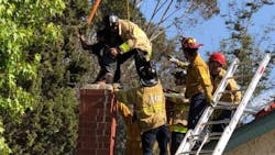 San Diego firefighters pull a man free from a chimney after he became stuck on Wednesday, July 11, 2018.