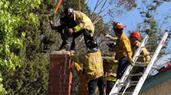 San Diego firefighters pull a man free from a chimney after he became stuck on Wednesday, July 11, 2018.