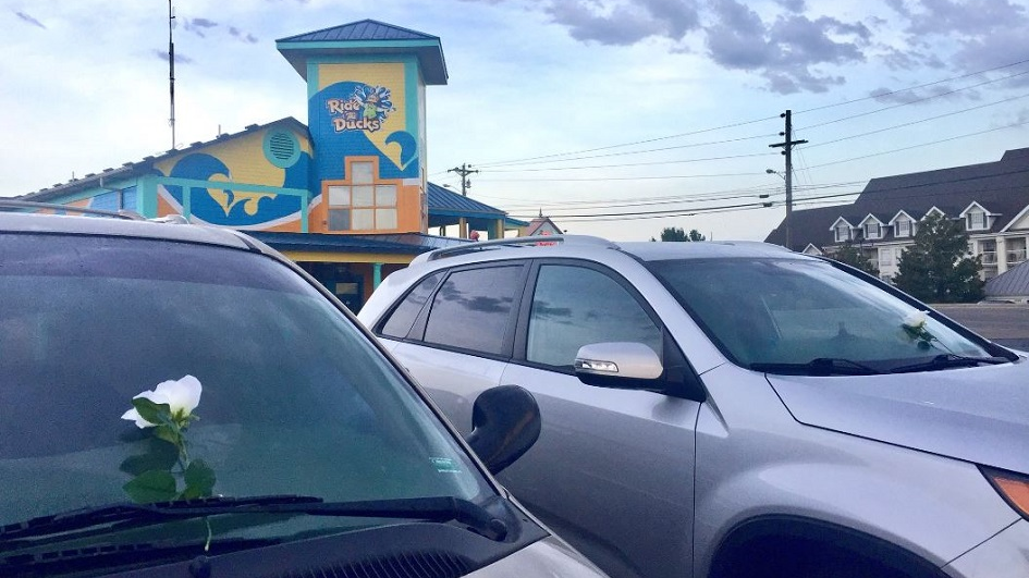 Flowers are left on vehicles in the parking lot of a 'Ride the Ducks' tourist boat business in Branson, MO, after 13 people died when one of the tour boats capsized on a lake during a storm on Thursday, July 19, 2018.
