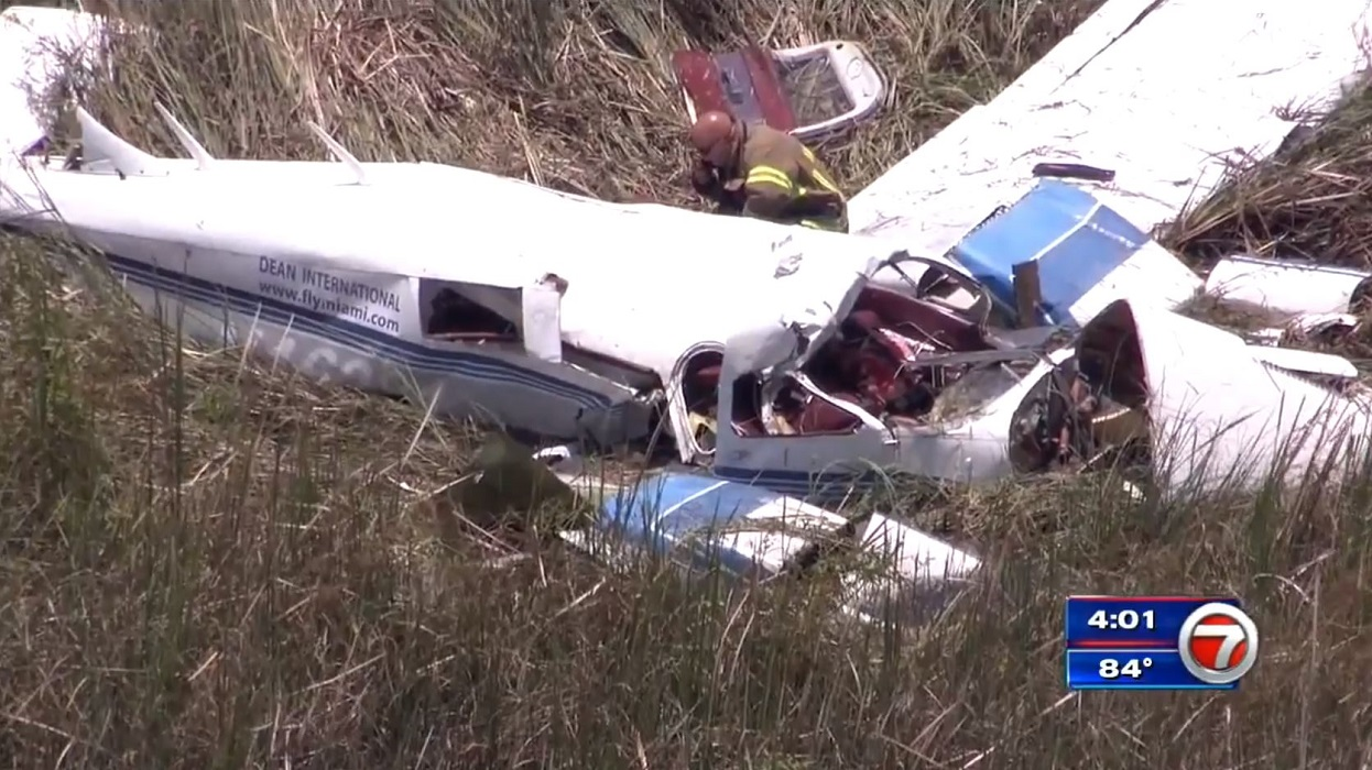 A Miami-Dade County firefighter kneels near the wreckage of a small plane that was involved in a fatal midair collision with another aircraft on Tuesday, July 17, 2018.