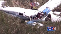 A Miami-Dade County firefighter kneels near the wreckage of a small plane that was involved in a fatal midair collision with another aircraft on Tuesday, July 17, 2018.