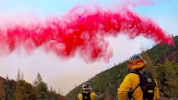 Firefighters battling the Ferguson Fire near Yosemite National Park look on as flame retardant material is dropped by an aircraft on Tuesday, July 17, 2018.