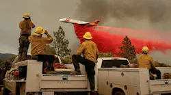 Firefighters watch a plane drop flame retardant on the Ferguson Fire in the Stanislaus National Forest on Sunday, July 22, 2018.
