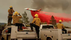 Firefighters watch a plane drop flame retardant on the Ferguson Fire in the Stanislaus National Forest on Sunday, July 22, 2018.
