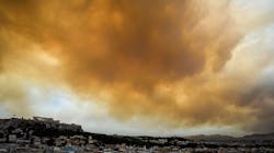 Smoke hovers over the ancient Acropolis hill as a wildfire burns west of Athens, Greece, on Monday, July 23, 2018.
