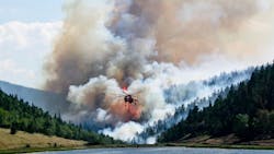A firefighting helicopter flies in the foreground while the Spring Creek Fire rages behind it. A firefighting helicopter flies in the foreground while the Spring Creek Fire rages behind it.