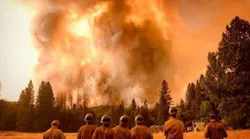 Firefighters look on as the growing Ferguson Fire rages in the background near Yosemite National Park in Mariposa County, CA, on Wednesday, July 18, 2018.