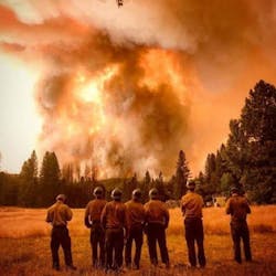 Firefighters look on as the growing Ferguson Fire rages in the background near Yosemite National Park in Mariposa County, CA, on Wednesday, July 18, 2018.