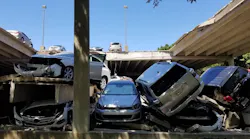 Cars sit piled on top of each other after the upper section of a parking garage in Irving, TX, collapsed on Tuesday, July 31, 2018.