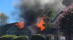 Firefighters battle a blaze in Williamsburg townhome complex following a possible helicopter crash.