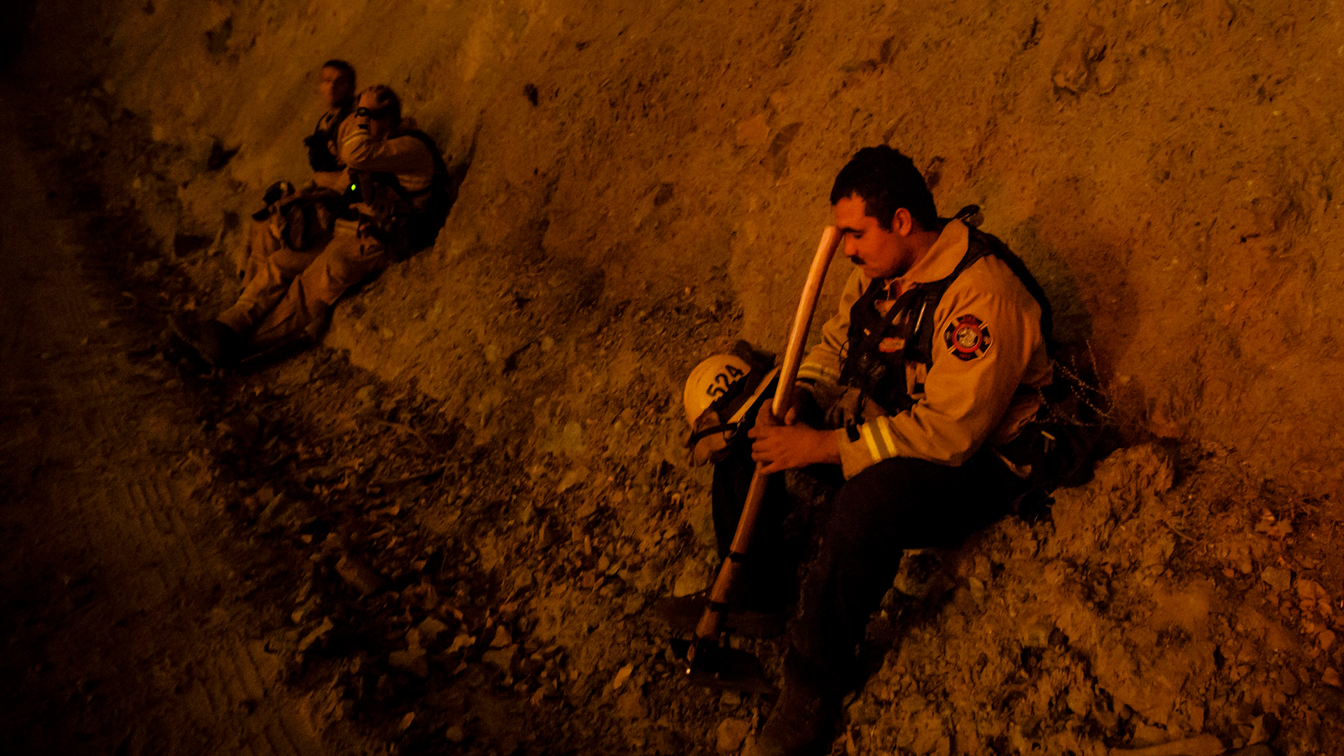 A firefighter takes a break during a burn operation near the town of Ladoga, CA, during the Mendocino Fire.