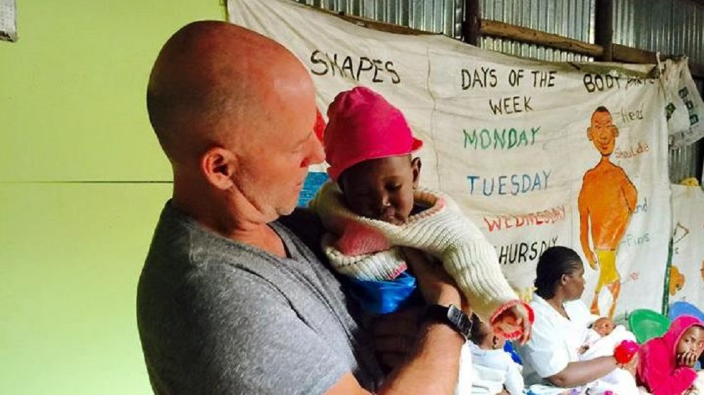 Burton, SC, fire Capt. Bobby Davidson holds a child being aided by his mission on one of his trips to Kibera outside Nairobi in Kenya in February 2018.