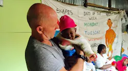Burton, SC, fire Capt. Bobby Davidson holds a child being aided by his mission on one of his trips to Kibera outside Nairobi in Kenya in February 2018.
