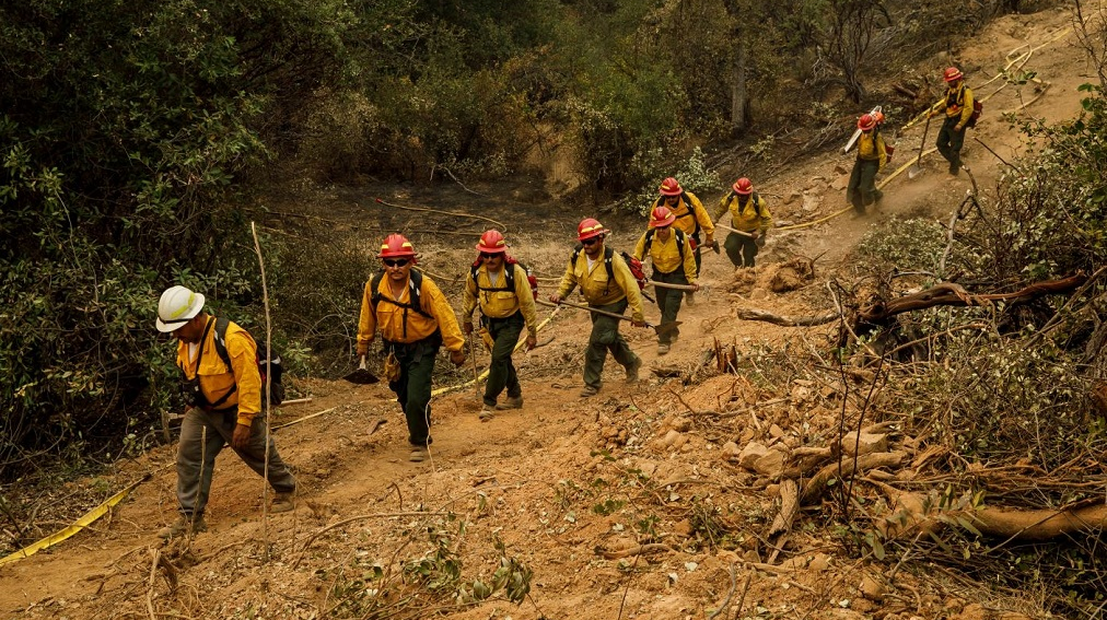Firefighters from S&R Contracting in Oregon walk the fire line as they head toward their assignment on the Carr Fire near Redding, CA, on Monday, July 30, 2018.