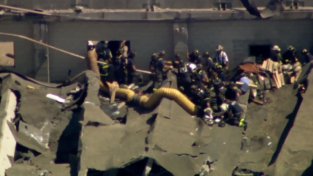 Chicago firefighters remove an injured person after an explosion caused the roof to collapse at the Calumet Water Reclamation Plant on the city's Far South Side on Wednesday, Aug. 30, 2018.