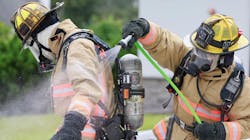 Orange County firefighters demonstrate use of a decontamination kit to hose deadly carcinogens off their gear on Thursday, Aug. 23, 2018.
