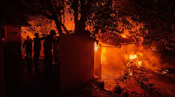 Three firefighters hose down a structure to slow the spread of the Carr Fire on Thursday, July 26, 2018, in Redding, CA.