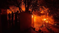 Three firefighters hose down a structure to slow the spread of the Carr Fire on Thursday, July 26, 2018, in Redding, CA. Three firefighters hose down a structure to slow the spread of the Carr Fire on Thursday, July 26, 2018, in Redding, CA.