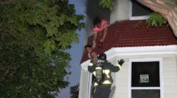 Boston firefighters rescue a woman and her child from a fire in a three-story building.