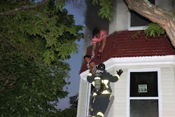 Boston firefighters rescue a woman and her child from a fire in a three-story building.