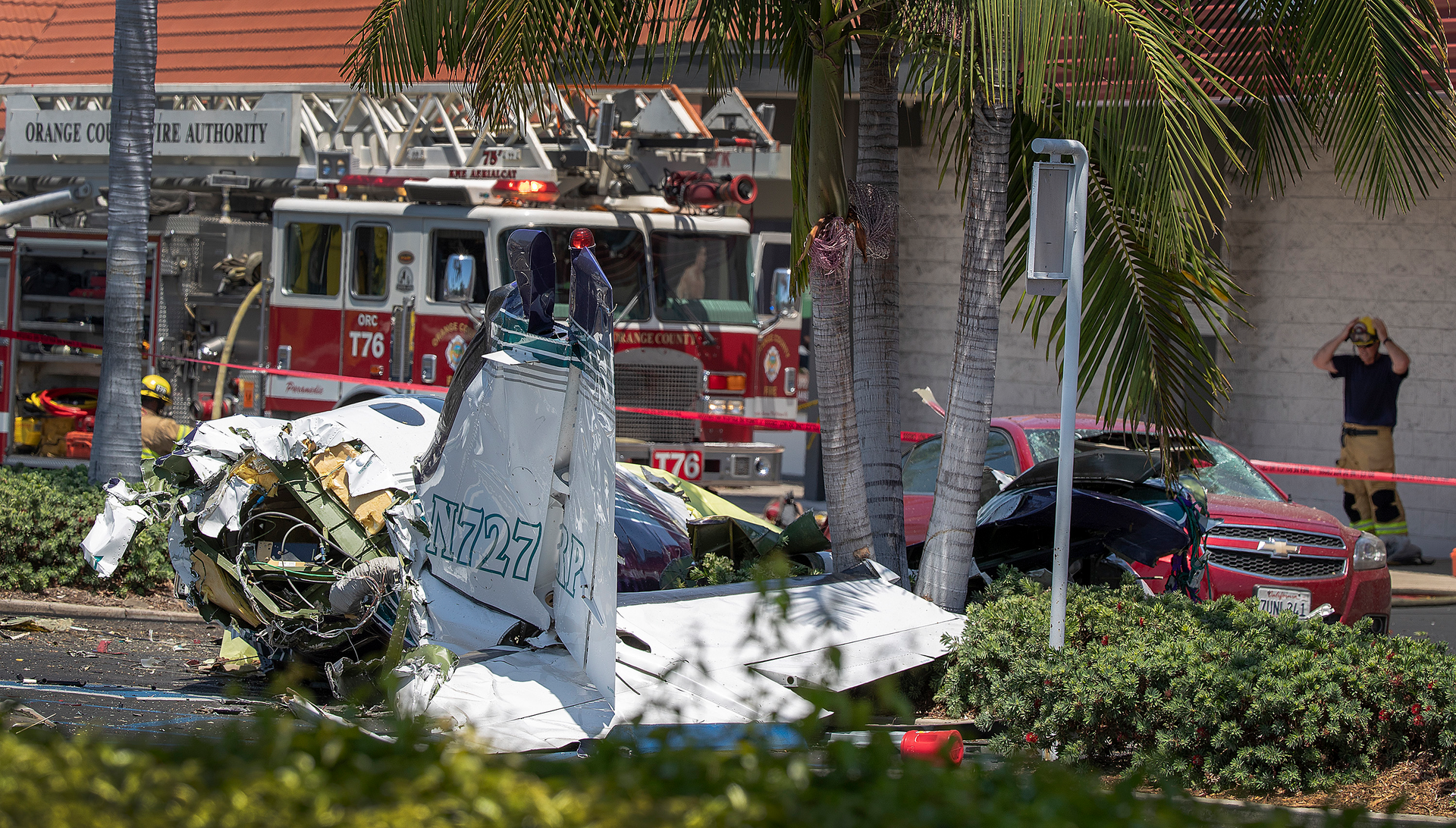 Orange County firefighters monitor the scene where five people were killed in a plane crash Sunday.